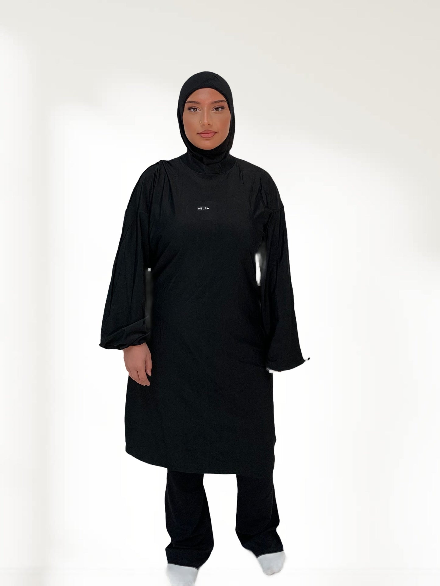 Ensemble modeste noir Ablaa pour sport et lifestyle, composé d’un top long et d’un pantalon ample couvrant, style sobre et fonctionnel