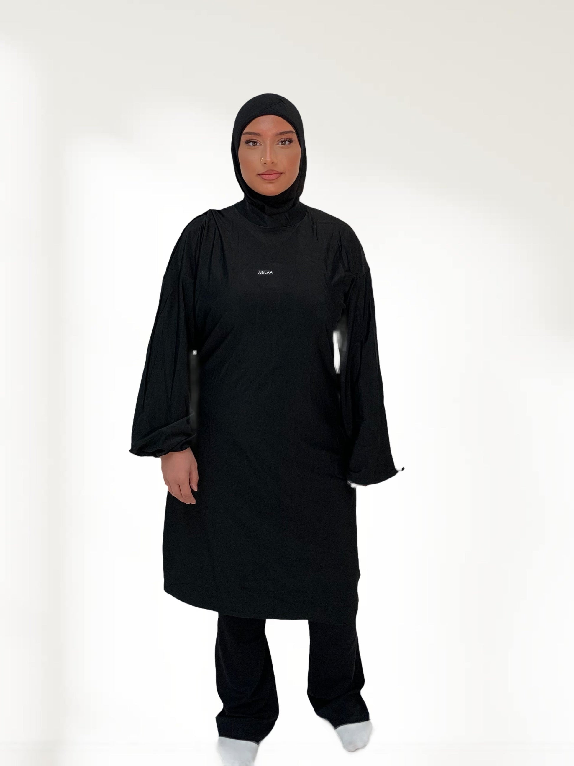 Ensemble modeste noir Ablaa pour sport et lifestyle, composé d’un top long et d’un pantalon ample couvrant, style sobre et fonctionnel