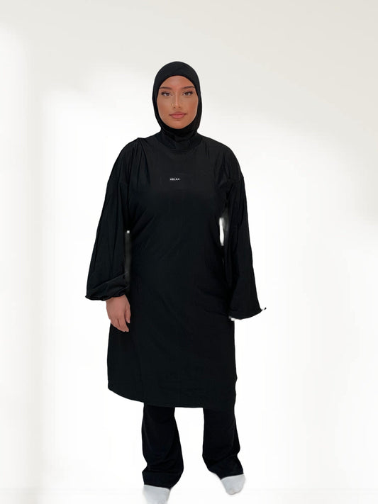 Ensemble modeste noir Ablaa pour sport et lifestyle, composé d’un top long et d’un pantalon ample couvrant, style sobre et fonctionnel